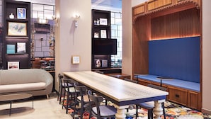 Een modern interieur met een lange tafel, stoelen, een bank en een zithoek met een comfortabele bank.