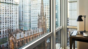 Uitzicht vanuit een raam op een stadsgezicht met hoge gebouwen en een opvallende kerktoren.