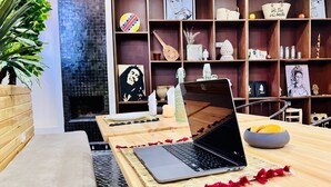 Ein modernes Wohnzimmer mit einem Holztisch, einem Laptop und einer Topfpflanze.