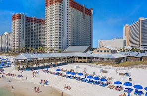 A beachside hotel with multiple buildings, a pier, and beach umbrellas. - Direct Beachfront, Wrap Balcony! Shores of Panama (Panama City Beach)