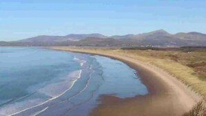 A coastal landscape with a sandy beach and a clear blue sky. - Cae Nest Hall (llanbedr)