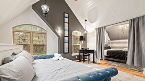 Une chambre avec un grand lit, un bureau et une vue sur l’extérieur.