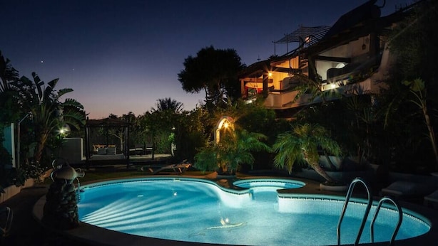 A swimming pool at dusk with a house in the background. - Pleasure of Mecca - Accommodation N4 with kitchen (Zahora)