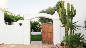Un edificio blanco con un sendero de ladrillo que lleva a una puerta de madera.