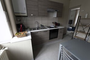 Una cocina moderna con horno empotrado, un lavamanos y un ventanal.