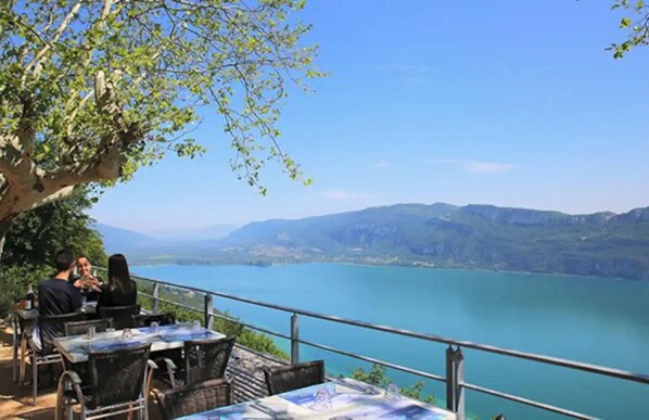 Sit and enjoy the serene views of the water and surrounding mountains from this shaded outdoor seating area.