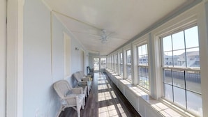 A corridor with wicker chairs, large windows, and a ceiling fan. - LARGE,Pool,pool table,Arcade,2 Golf Carts,6 Kayaks,free linen,Hot Tub,near beach (Murrells Inlet)