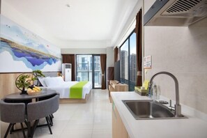 A hotel room with a bed, a dining table with chairs, a kitchen area with a sink, and a large window with a city view. - Light Time Hotel (Nanning Greenland Central Plaza) (Nanning)