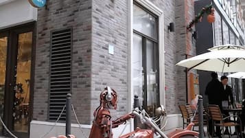 Un edificio de ladrillo con escaparate y zona de mesas al aire libre.
