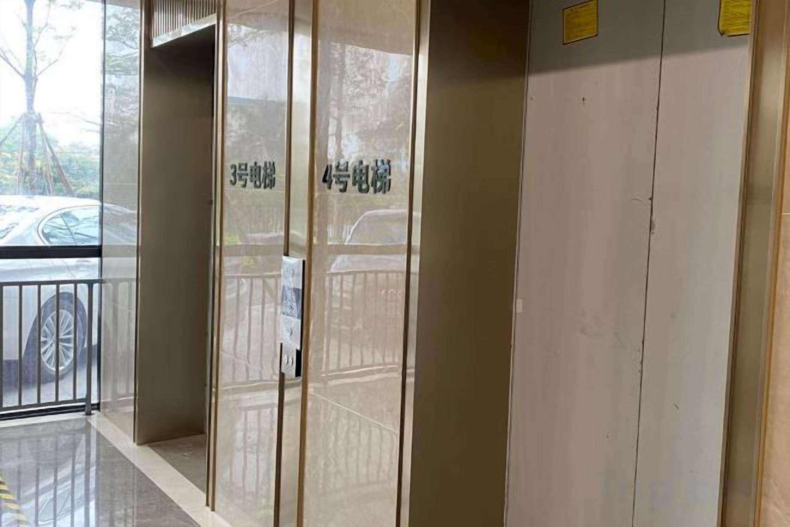 A hotel entrance with a glass door, a metal gate, and a parking area visible through the glass.