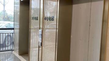 A hotel entrance with a glass door, a metal gate, and a parking area visible through the glass.