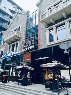 Un edificio con una cafetería y una tienda de chocolates en la planta baja.