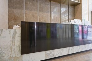 A reception desk with a marble counter and a black panel, likely for check-in or information. - Light Time Hotel (Nanning Greenland Central Plaza) (Nanning)
