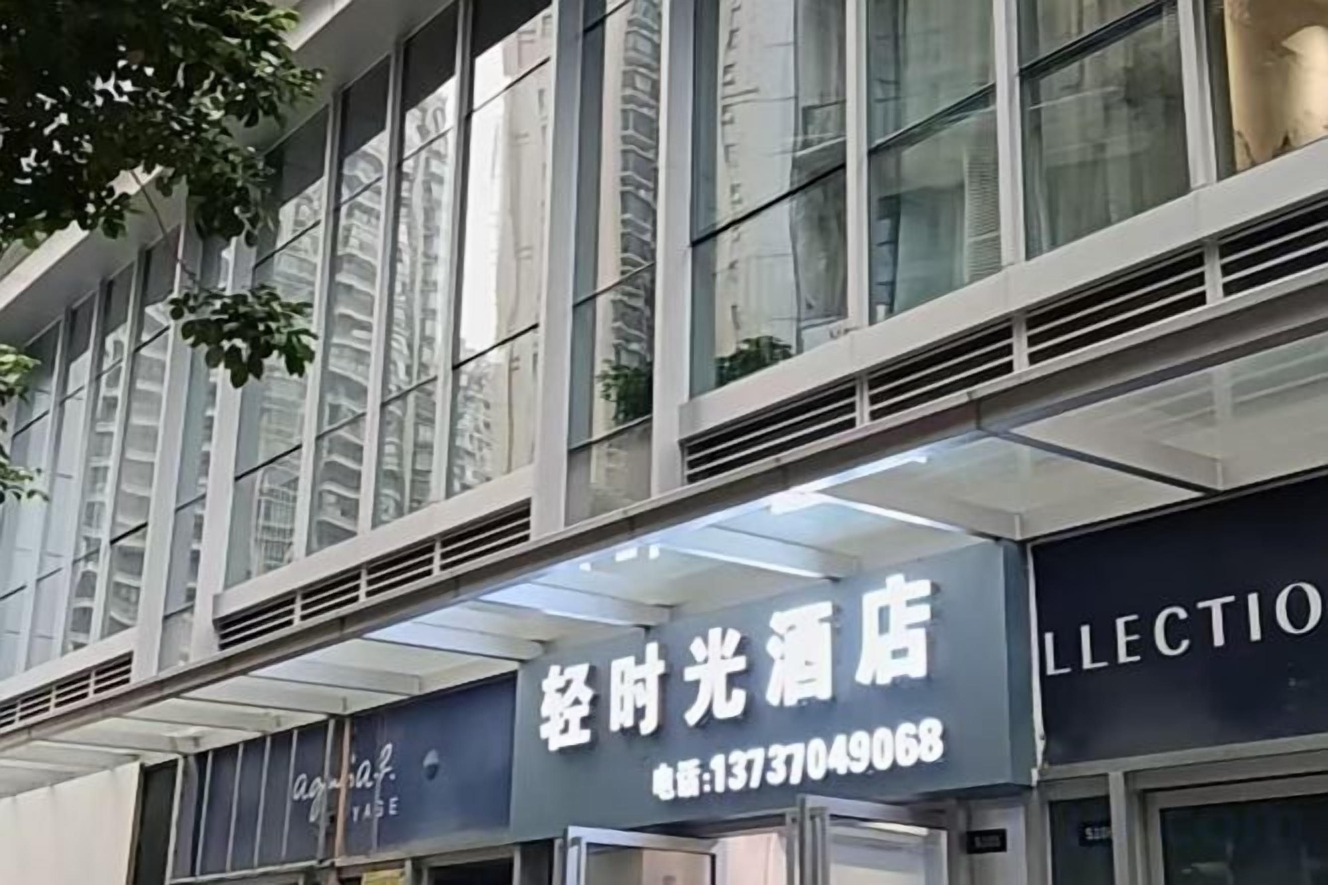 Un edificio con un cartel que dice 'LLECTION' y un número de contacto.