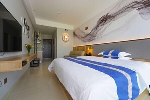 A modern hotel room with a large bed, a TV mounted on the wall, a desk with a computer, and a decorative wall piece. - Light Time Hotel (Nanning Greenland Central Plaza) (Nanning)