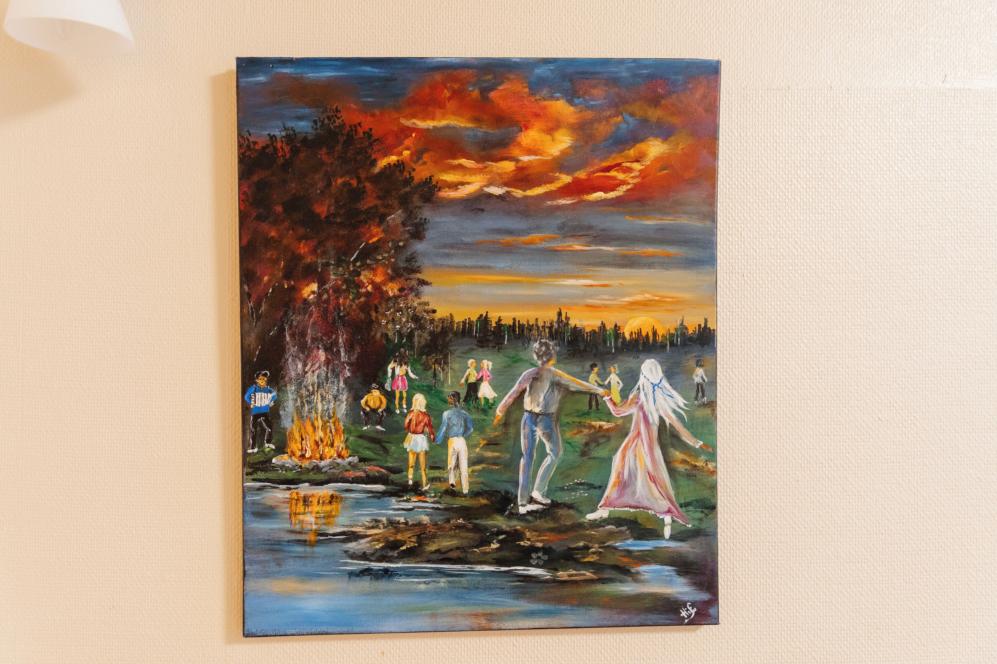 A painting of people by a river at sunset.