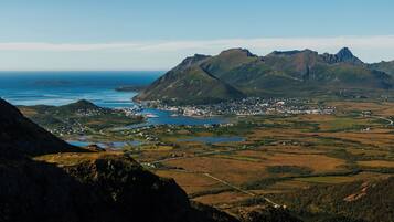 A mountainous landscape with a town and a body of water.