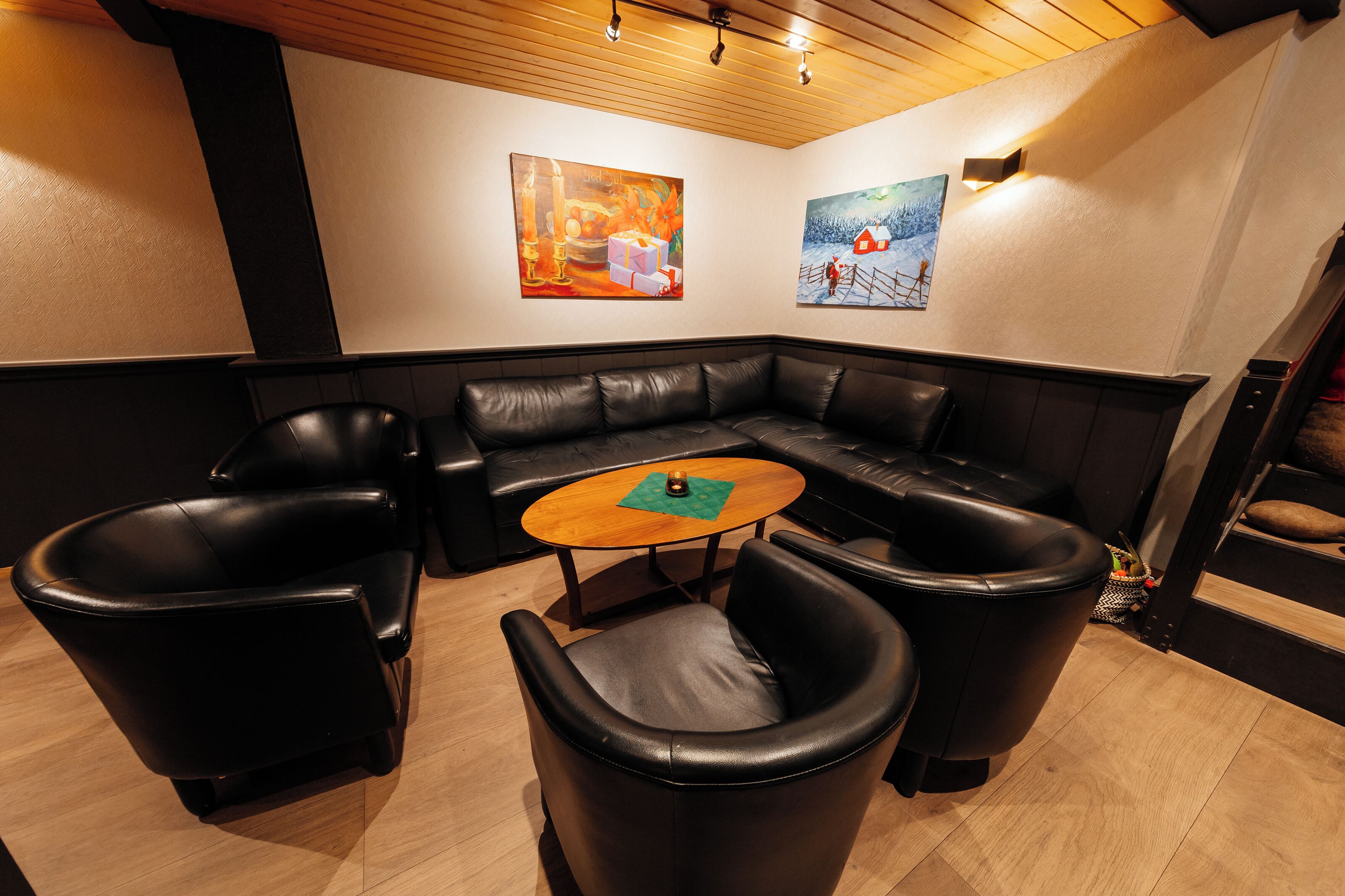 A modern lounge area with a sectional sofa, two armchairs, and a small round table.