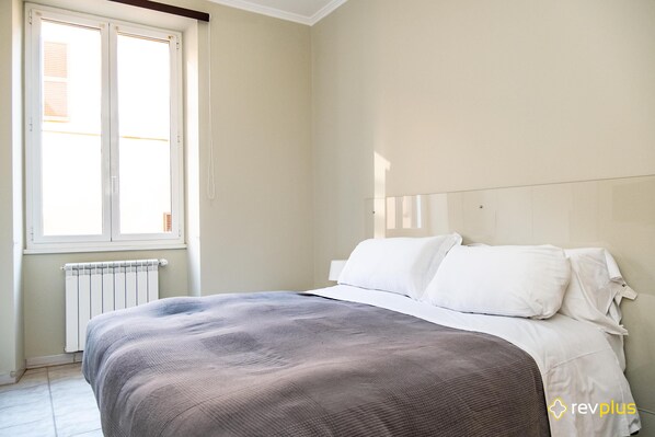 A bedroom with a bed, a window, and a radiator. - Mecenate Apartment Cavour (Rome)
