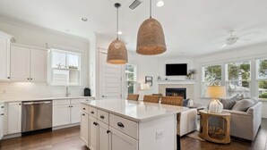 A spacious kitchen with white cabinetry, a central island, and hanging wicker pendant lights. - GORGEOUS Highland Parks w LSV & Bikes! Loaded 30A Home! (Santa Rosa Beach)