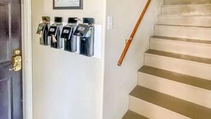A staircase with a handrail, a door with a doorknob, and a wall-mounted mailbox. - Sealy Suites D  Historic East End - Walk to Beach, UTMB & Strand  (Galveston)