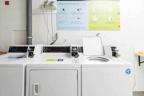 A laundry facility with multiple washing machines and a control panel. - LA CICER BEACH APARTMENT ll (Palmas De Gran Canaria, Las)