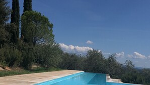 Una piscina cristallina con un bordo sabbioso, circondata da vegetazione e alberi.