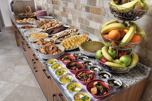 Un bufé con diversos platos y frutas.