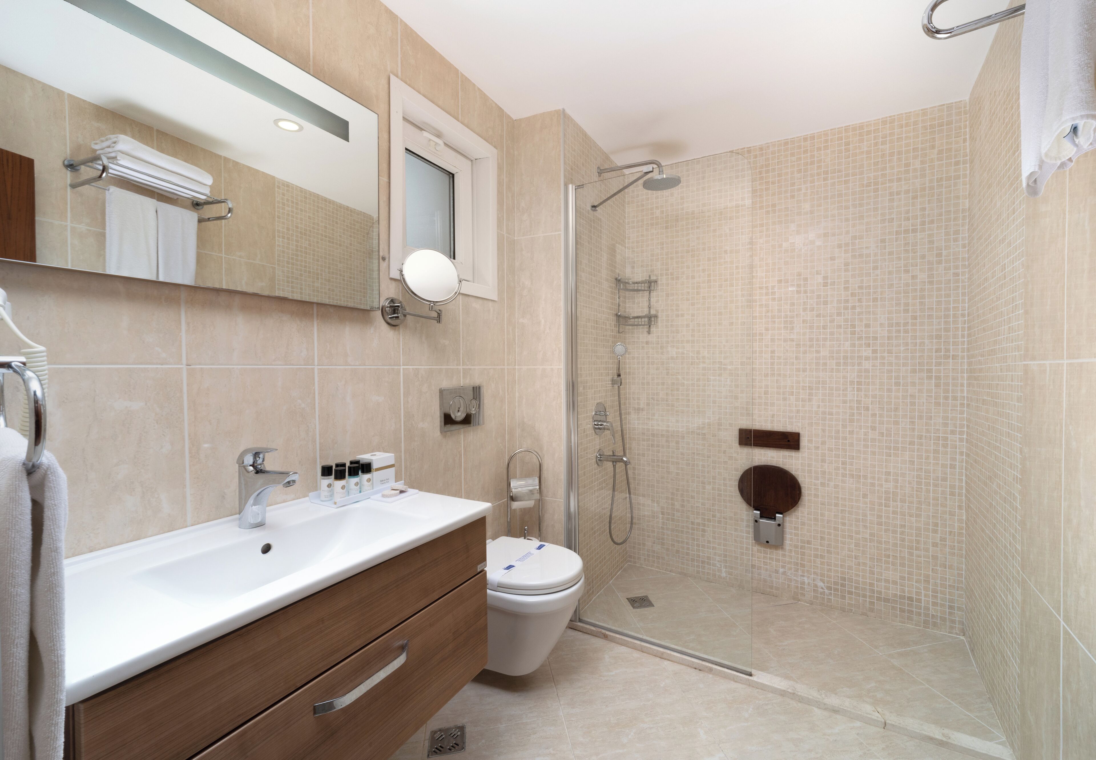 A modern bathroom with a sink, mirror, toilet, and shower.