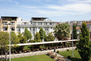 Ein Hotel mit Außenbestuhlung, einer überdachten Terrasse und Blick auf die Stadt.