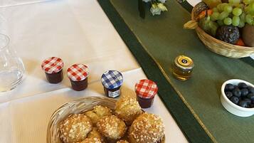 A table set for a meal with bread, flowers, and fruit baskets.