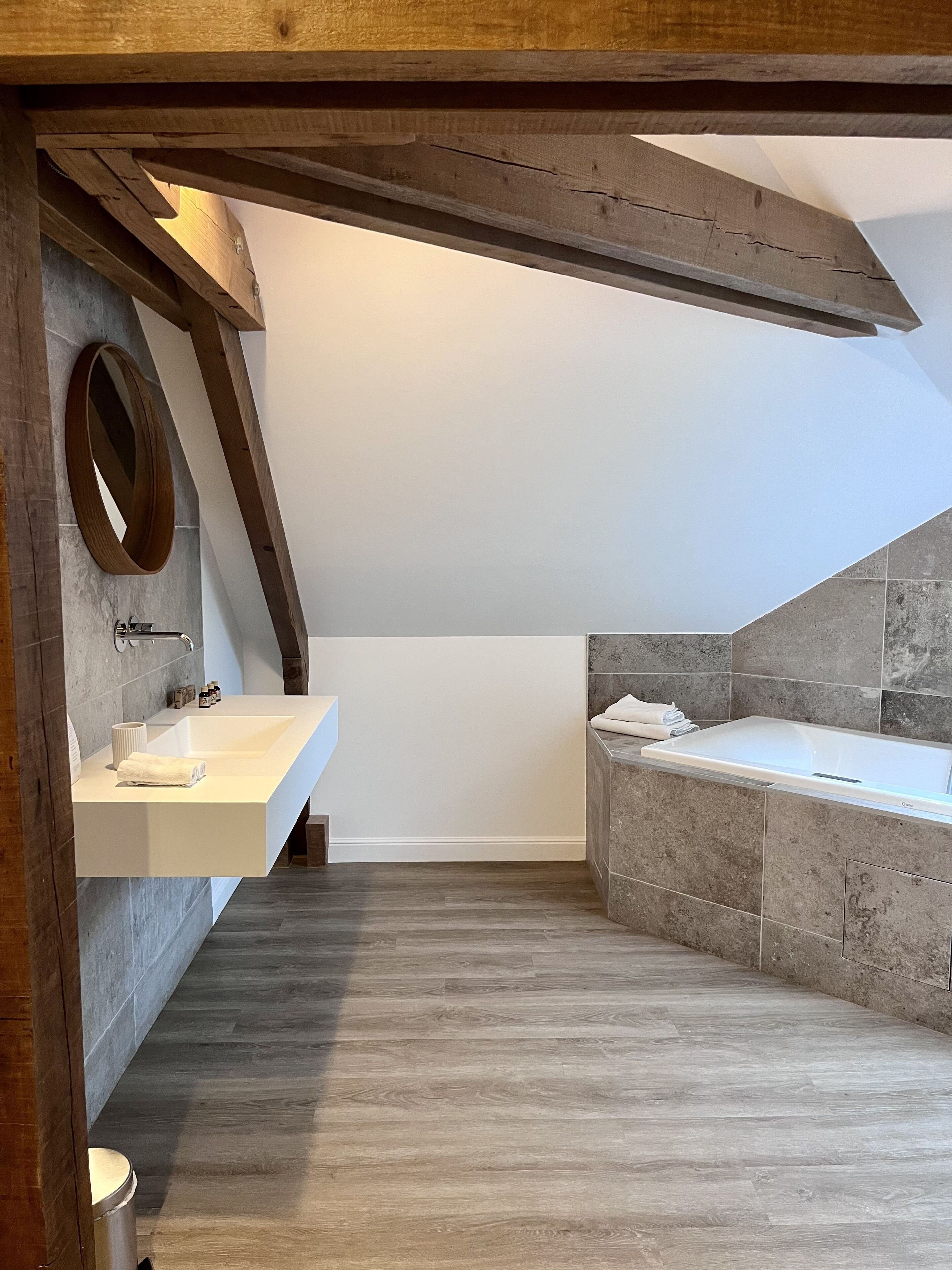 A modern bathroom with a freestanding bathtub, a large mirror, and a built-in sink.