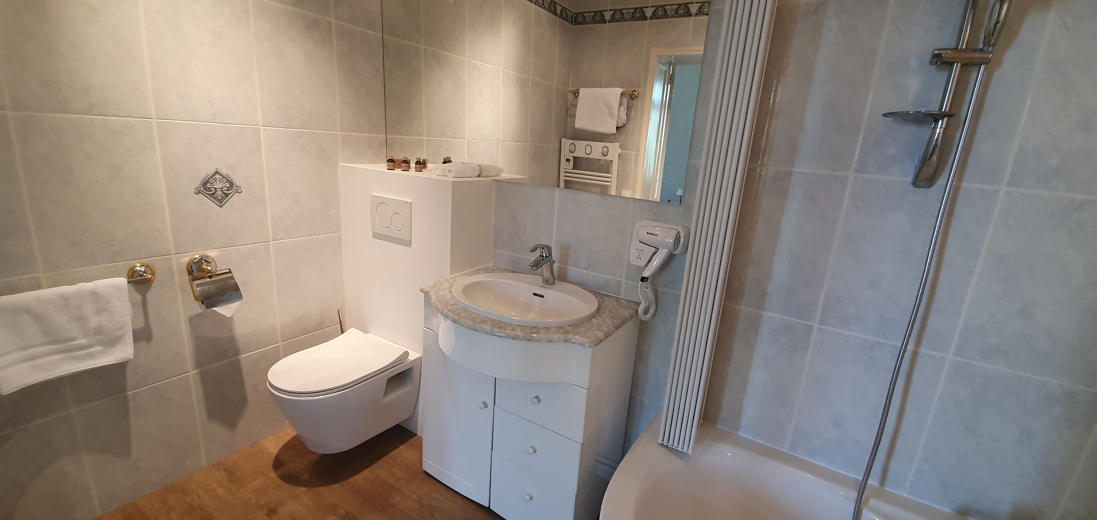 A bathroom with a toilet, sink, and shower.
