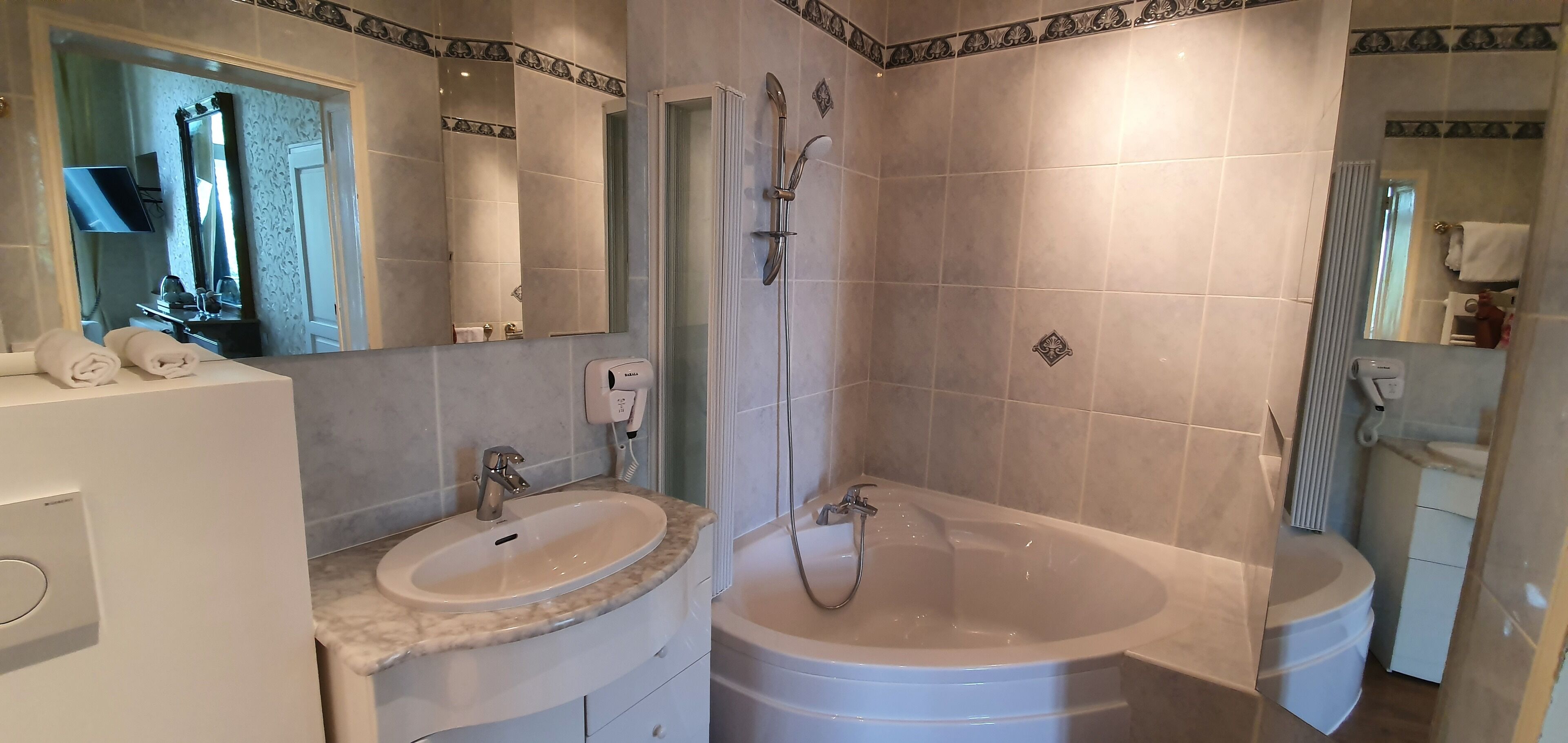 Une salle de bain avec un lavabo, un miroir et une baignoire.