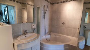 Une salle de bain avec un lavabo, un miroir et une baignoire.