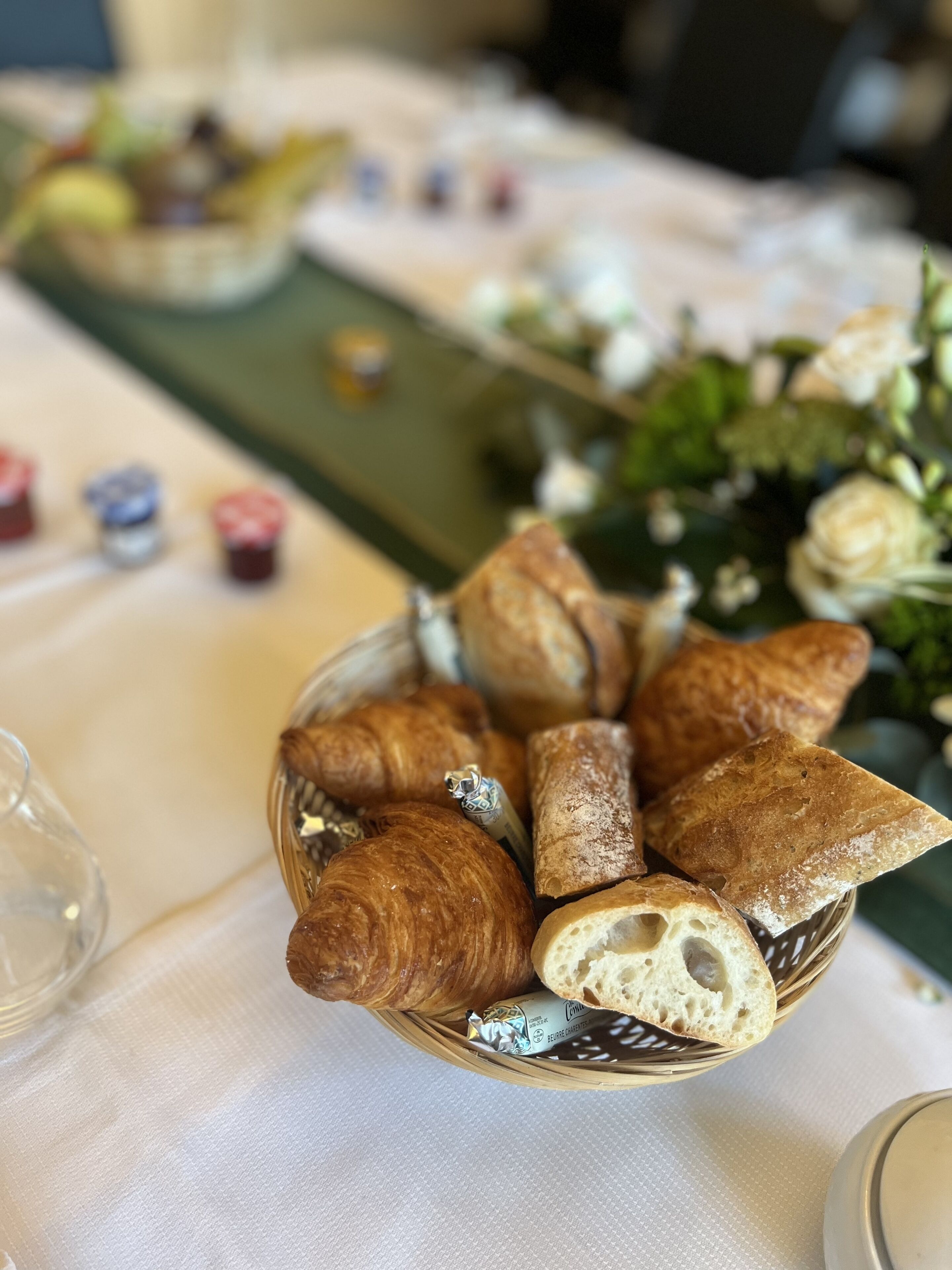 Un tavolo con un cesto di dolci misti e un bicchiere d'acqua.