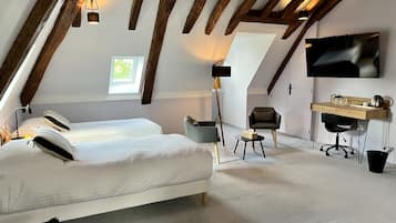 Une chambre avec un grand lit, un bureau, une chaise et un téléviseur.