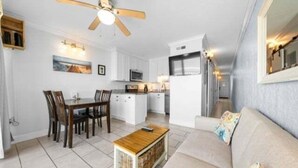 A compact living space with a dining area, kitchenette, and a sofa. - Southern Comfort - Expansive Views Of The Ocean And Beach! Newly Renovated Plus Top Grade Linens! 2 Bedroom Condo by RedAwning (Carolina Beach)