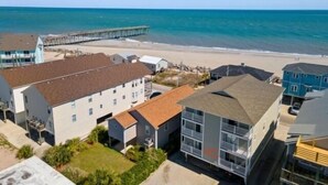 Une zone résidentielle côtière comprenant des immeubles, une jetée et une plage.