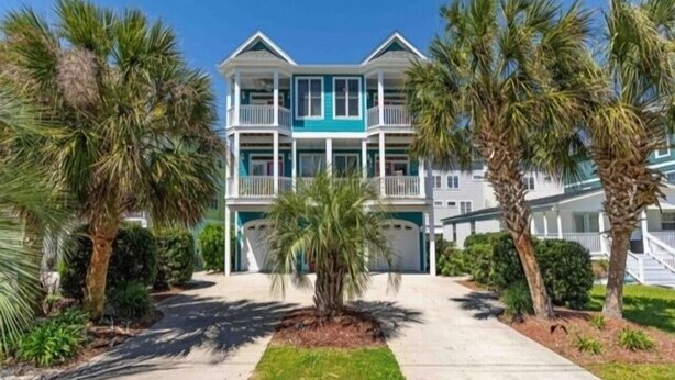 A two-story beachfront property with a covered driveway and a well-maintained lawn. - After Dune Delight - Relax And Unwind In This Fun And Spacious 3 Story Home. Light, Bright, And Close To Everything! 4 Bedroom Townhouse by RedAwning (Carolina Beach)