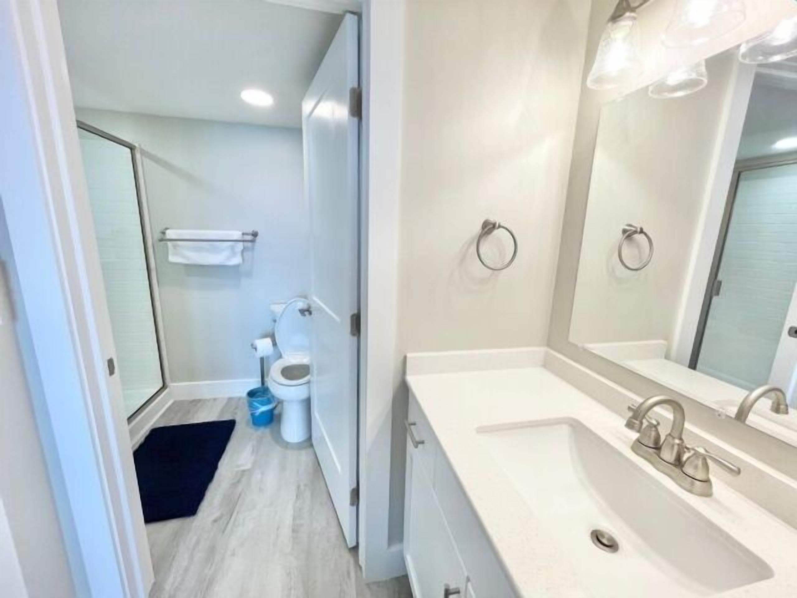 Ein modernes Badezimmer mit Waschbecken, Spiegel und Toilette.