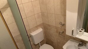 Ein kleines Badezimmer mit Toilette, Waschbecken und Dusche.