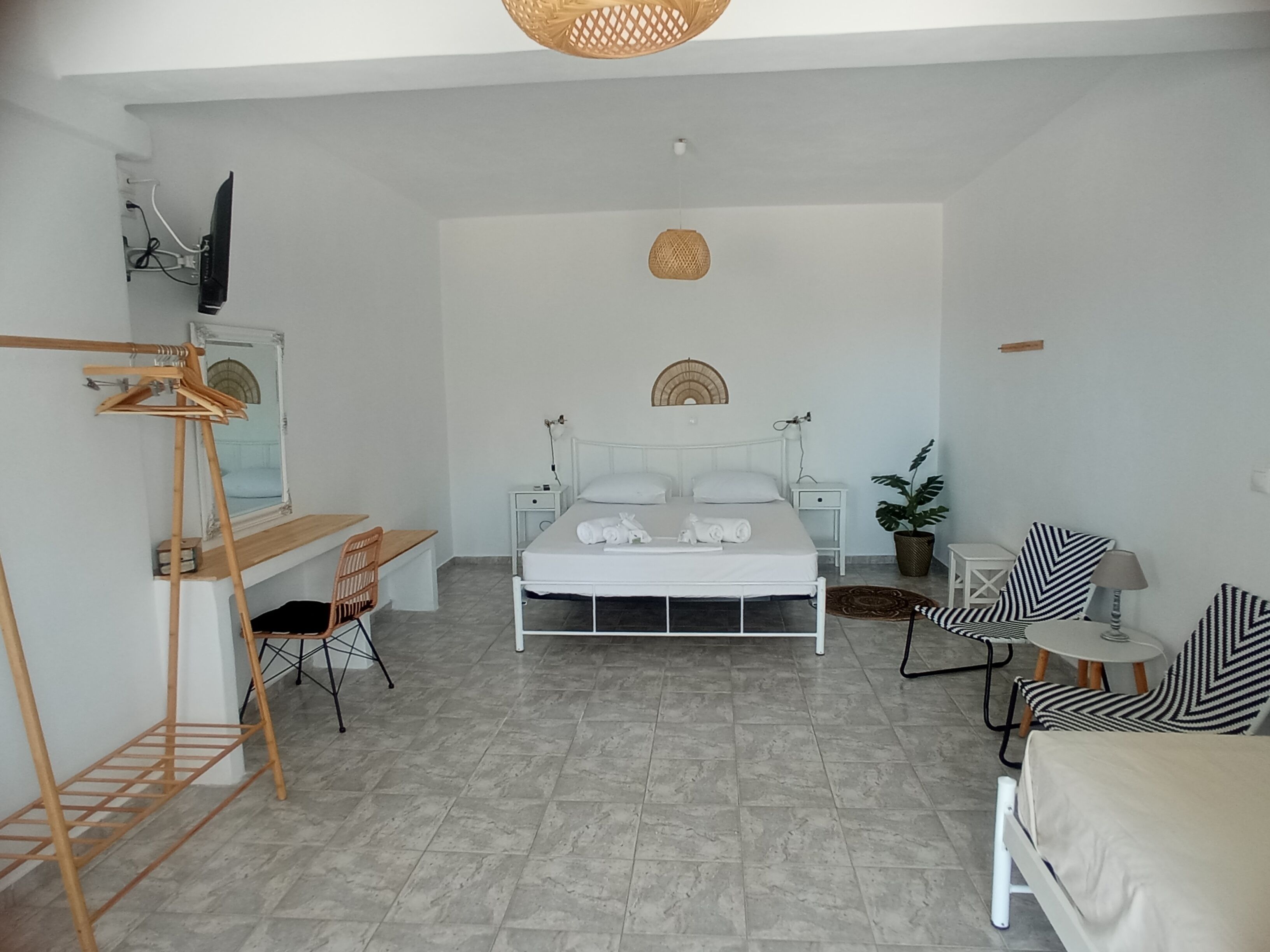 Quarto minimalista com cama, escrivaninha e cadeira.
