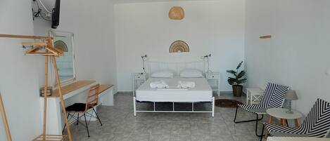 A minimalist bedroom with a bed, a desk, and a chair.