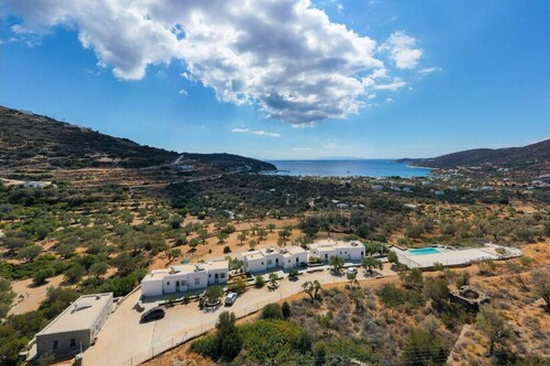 Propiedad costera con varias edificaciones blancas, una piscina y vista al mar.