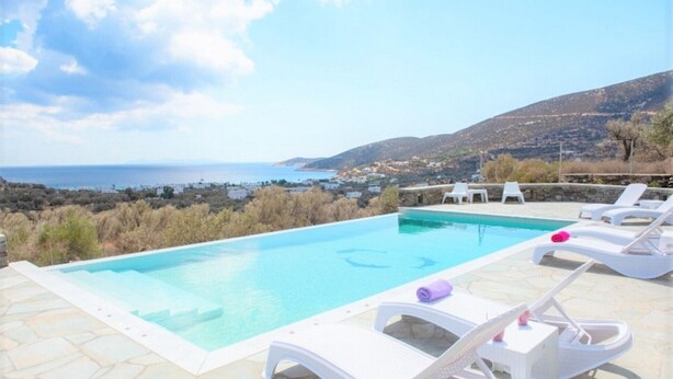A swimming pool with white lounge chairs and a view of the sea and hills. - Ktima Vrisiana (Sifnos)