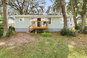 A single-story house with a front porch, a small deck, and a staircase leading to the front door.