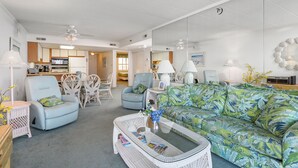 A spacious living area with a sofa, chairs, a coffee table, and a dining table.