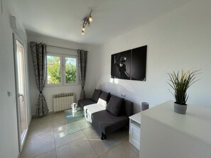 A modern living room with a sofa, a glass coffee table, a potted plant, and a wall-mounted artwork. - T-0621, Campo Olivar, townhouse in Campo Olivar, Els Poblets (els poblets)