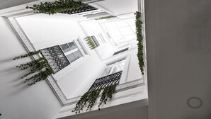 A modern building with white walls, large windows, and black metal railings.